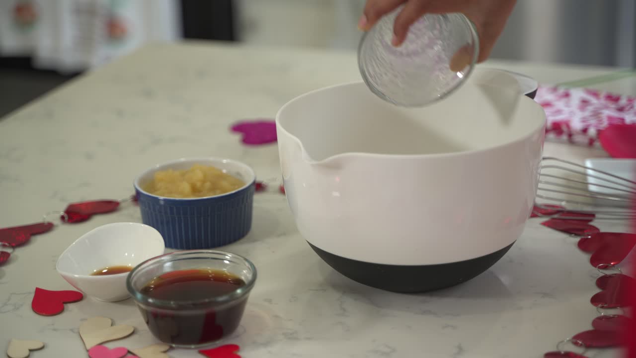 añadiendo aceite de coco a un tazón de masa haciendo un pastel especial del día de san valentín pastel de chocolate vegano sin huevos a base de plantas sin lácteos