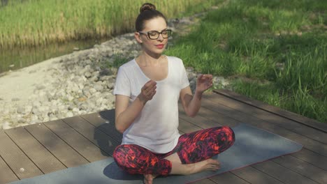mujer joven meditando sobre una alfombra