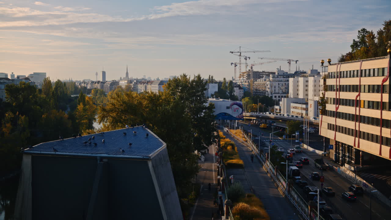 vista de la ciudad de viena austria mientras las fachadas de los edificios están iluminadas por luz dorada, grúas altas en la distancia