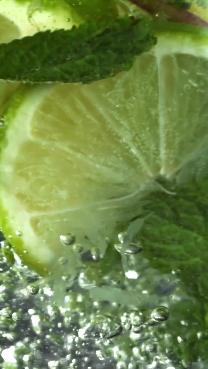 Fette rinfrescanti di lime e menta che frizzano in una bevanda gassata
