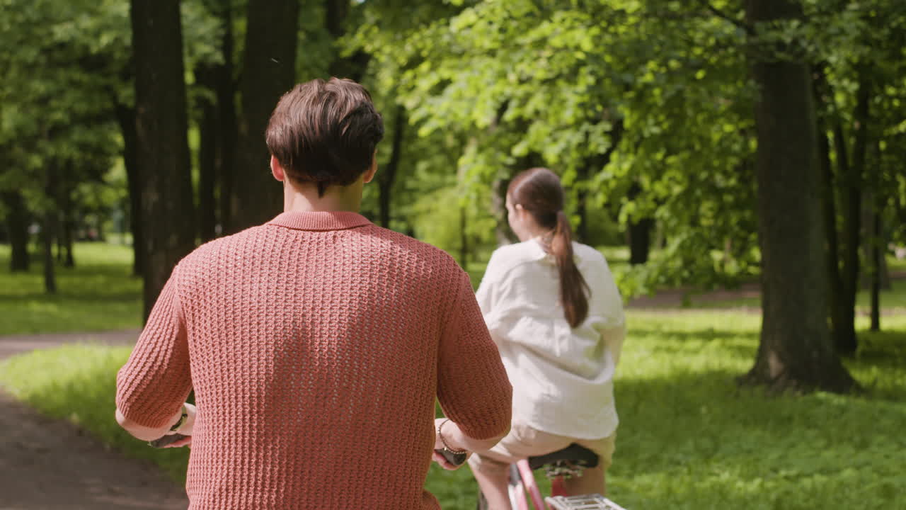 Couple riding bicycles in a park