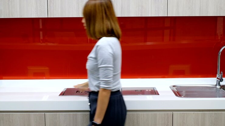 Una donna getta una tazza di caffè nel cestino in ufficio.