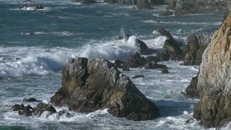 onde invernali che si infrangono contro le rocce della grande costa della california