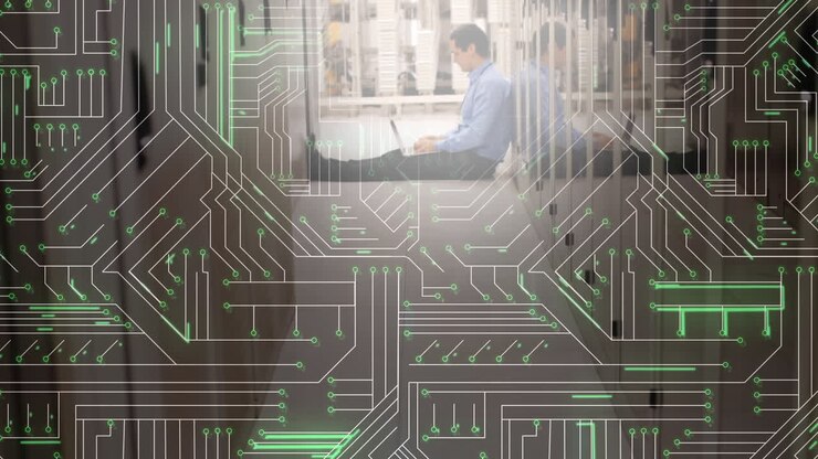 Man using laptop in server room and glowing circuit board