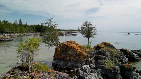 Ascenso-Aéreo-Sobre-Grandes-Rocas-En-La-Orilla-Del-Lago,-Islas-Les-Cheneaux,-Michigan