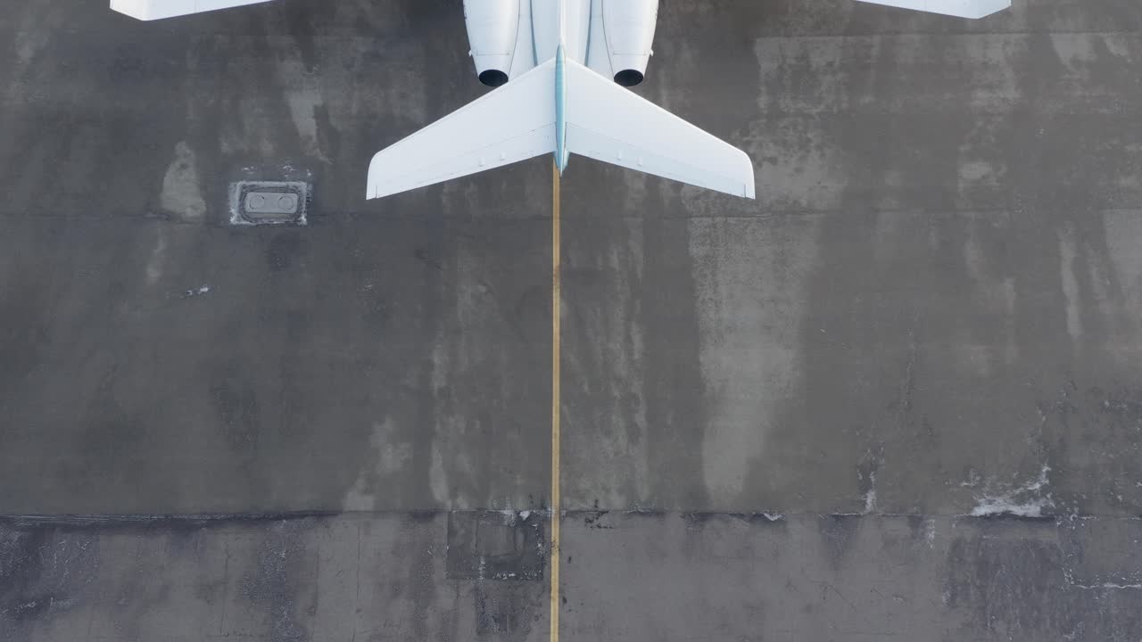 detrás de un gran avión privado estacionado en un aeropuerto de hormigón, revelar tiro