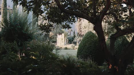 mire a través del jardín verde de la famosa ubicación de la boda de villa balbiano hacia un antiguo detalle histórico de la puerta de piedra