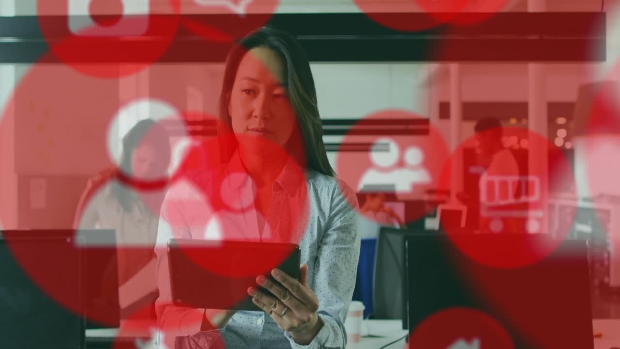 Mid-age woman scrolling tablet in office as red user and cart icons appearing, driving sales checks
