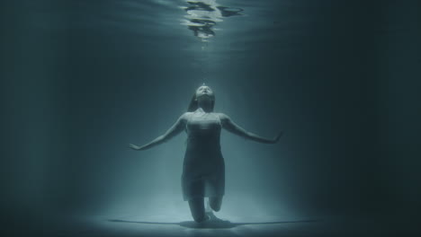 girl froze under water at the bottom looking up