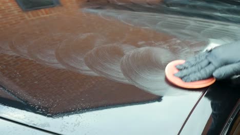 polishing a black car by hand - close up