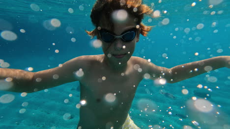 un adolescente nada bajo el agua.