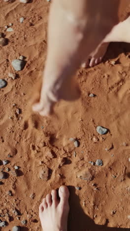 bare feet on red desert sand