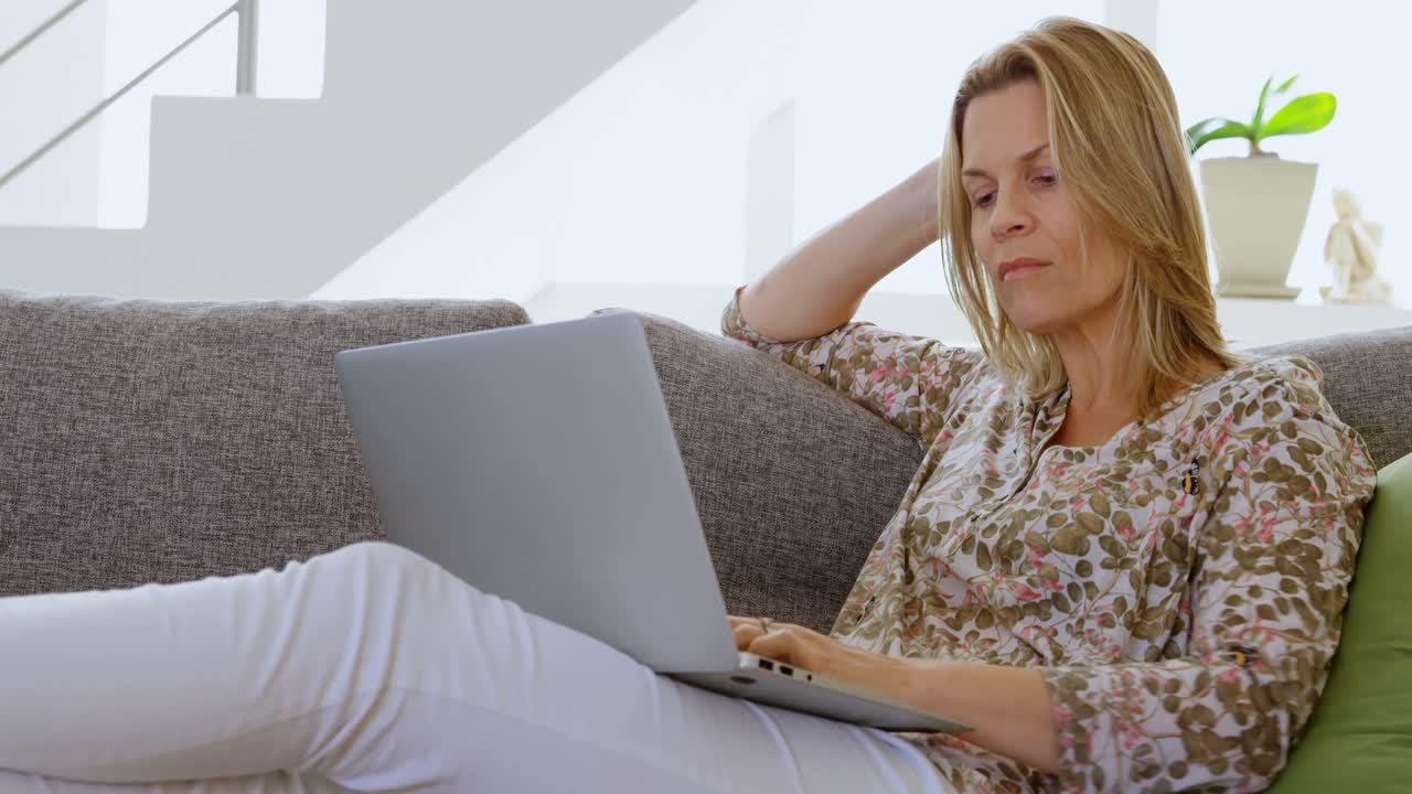Woman using laptop in living room 4k