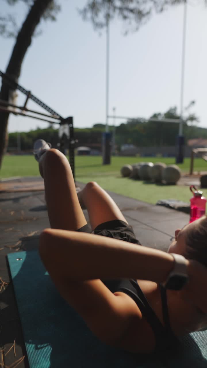 mujer haciendo abdominales al aire libre