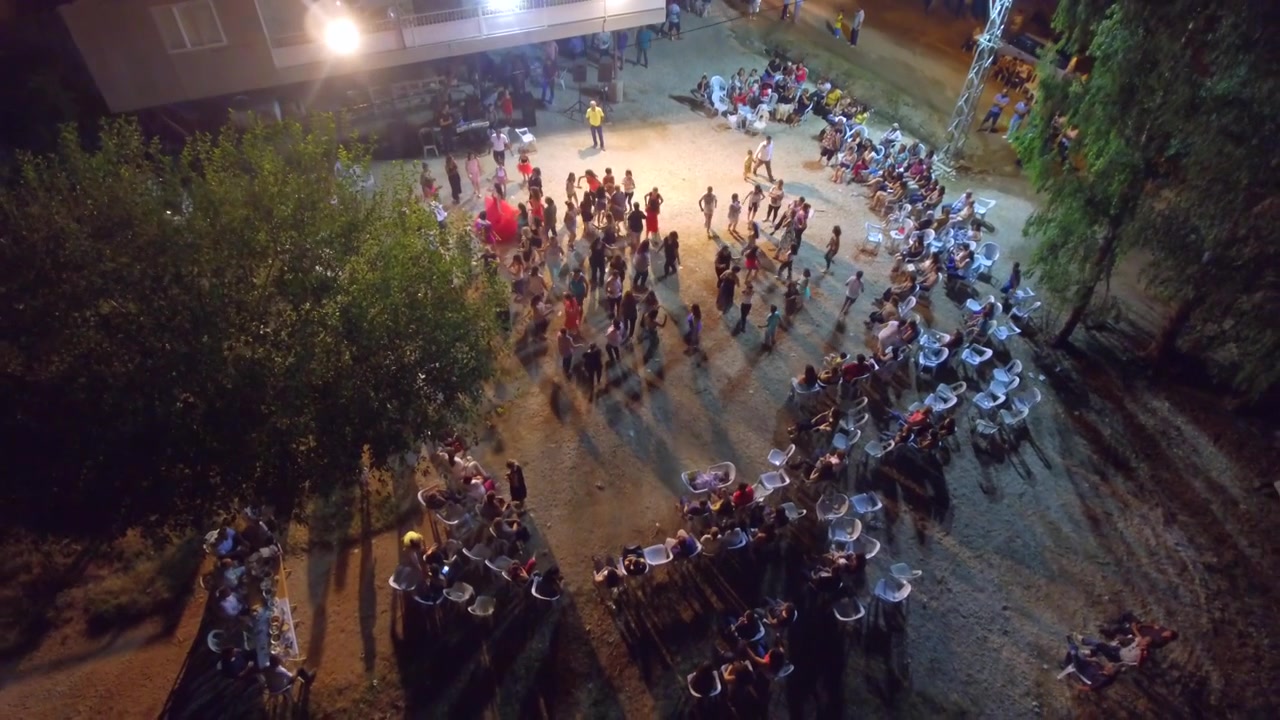 People Dancing in a Circle at an Outdoor Night Event
