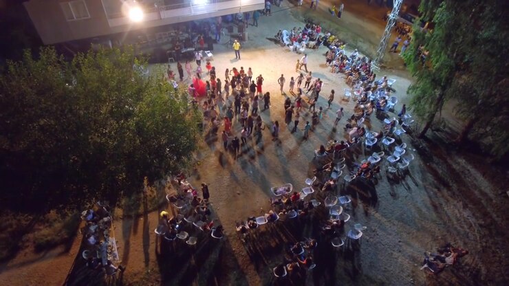 People Dancing in a Circle at an Outdoor Night Event