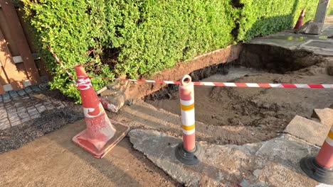 traffic cones and tape around a trench.