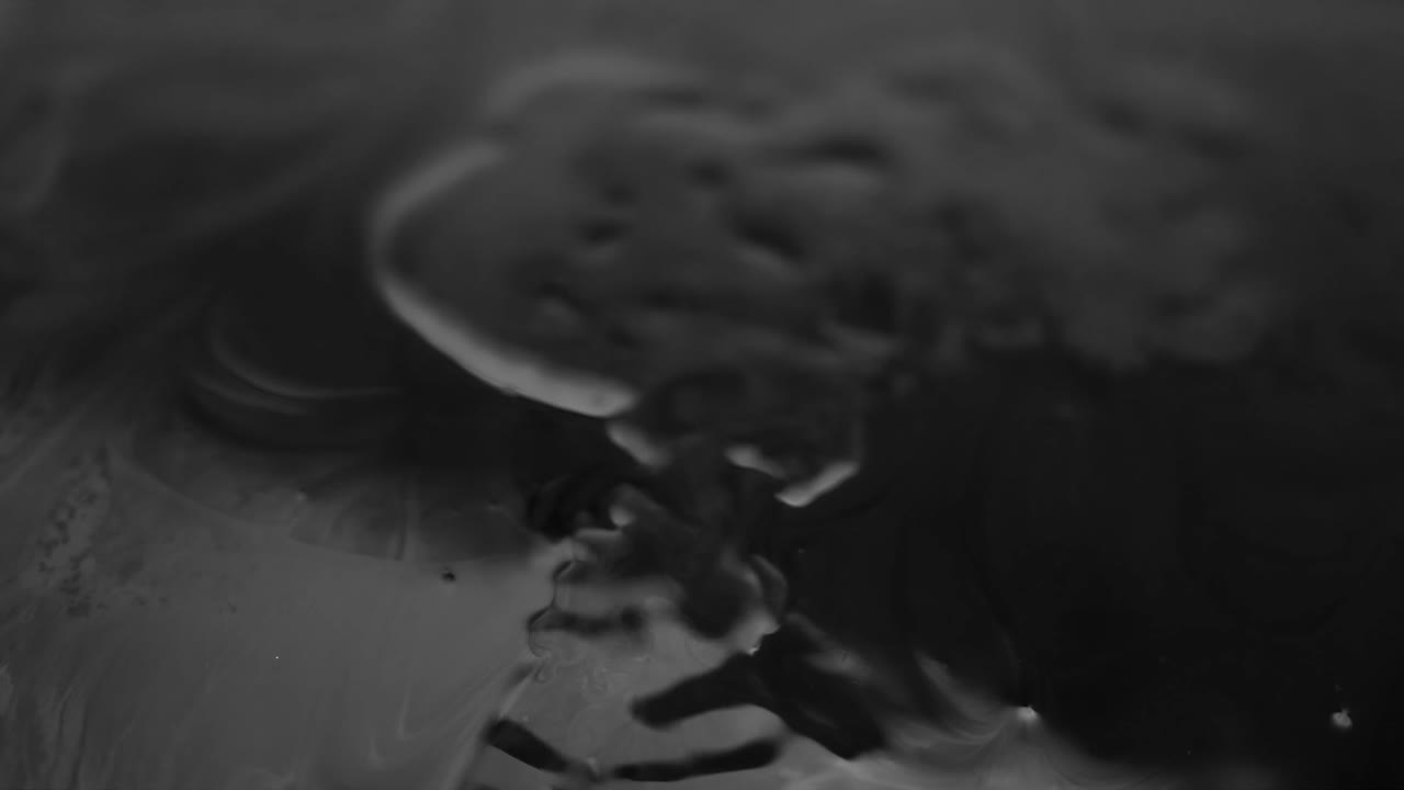 Black liquid droplet cascade downward onto a wet, watery surface, generating a ripple effect, illustrating the concept of fluidity, transformation, and interconnectedness