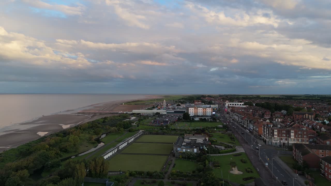 Aerial View of a Coastal Town at Dusk, Featuring Beach, Pier, and Urban Landscape