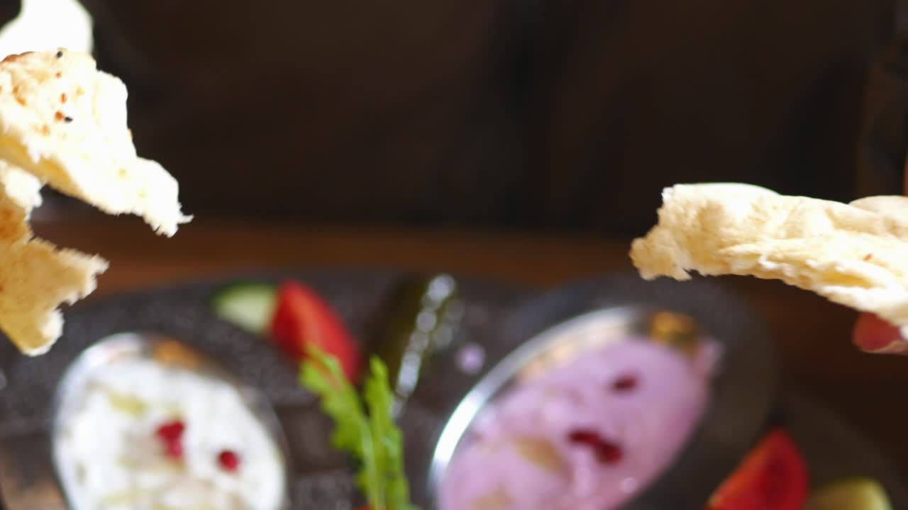 Hands Tearing Flatbread at a Meal