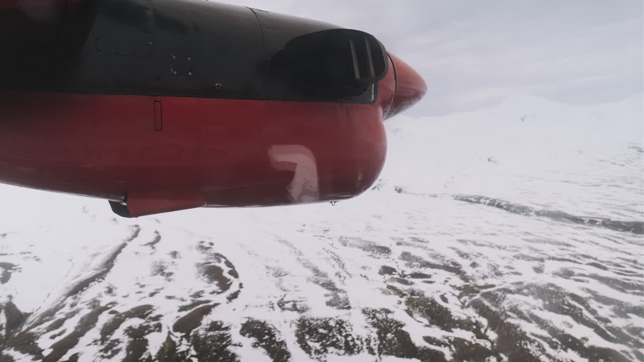 primer plano de la hélice giratoria en un pequeño avión que volaba sobre montañas cubiertas de nieve, islandia