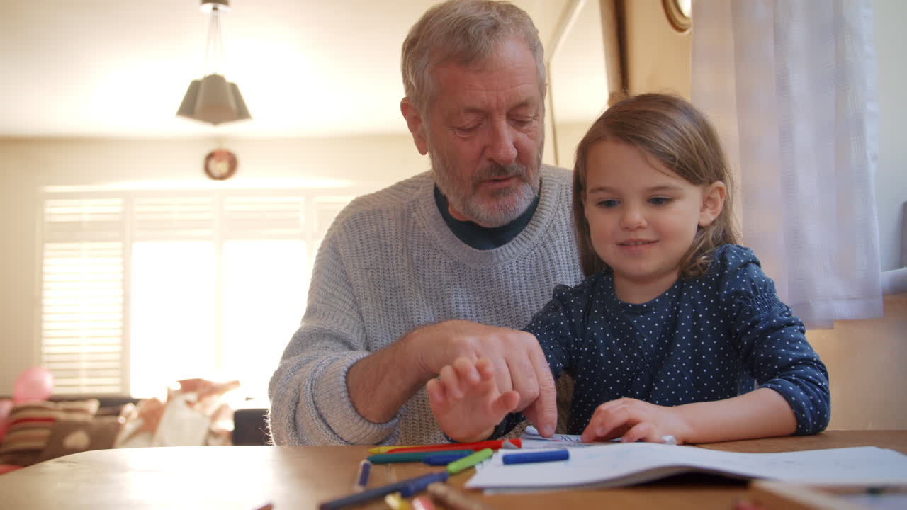 abuelo y nieta coloreando imágenes juntos
