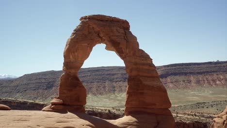 Handheld-wide-shot-of-a-beautiful-natural-red-sandstone-rock-arch-caused-from-millions-of-years-of-erosion-on-a-hot-sunny-summer-day-in-southern-Utah-on-a-hike-on-vacation