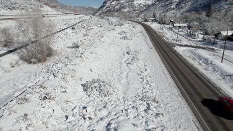 Tilt-up-with-a-vehicle-driving-the-Grand-Army-of-the-Republic-Highway-with-I-70-and-mountains-in-the-background