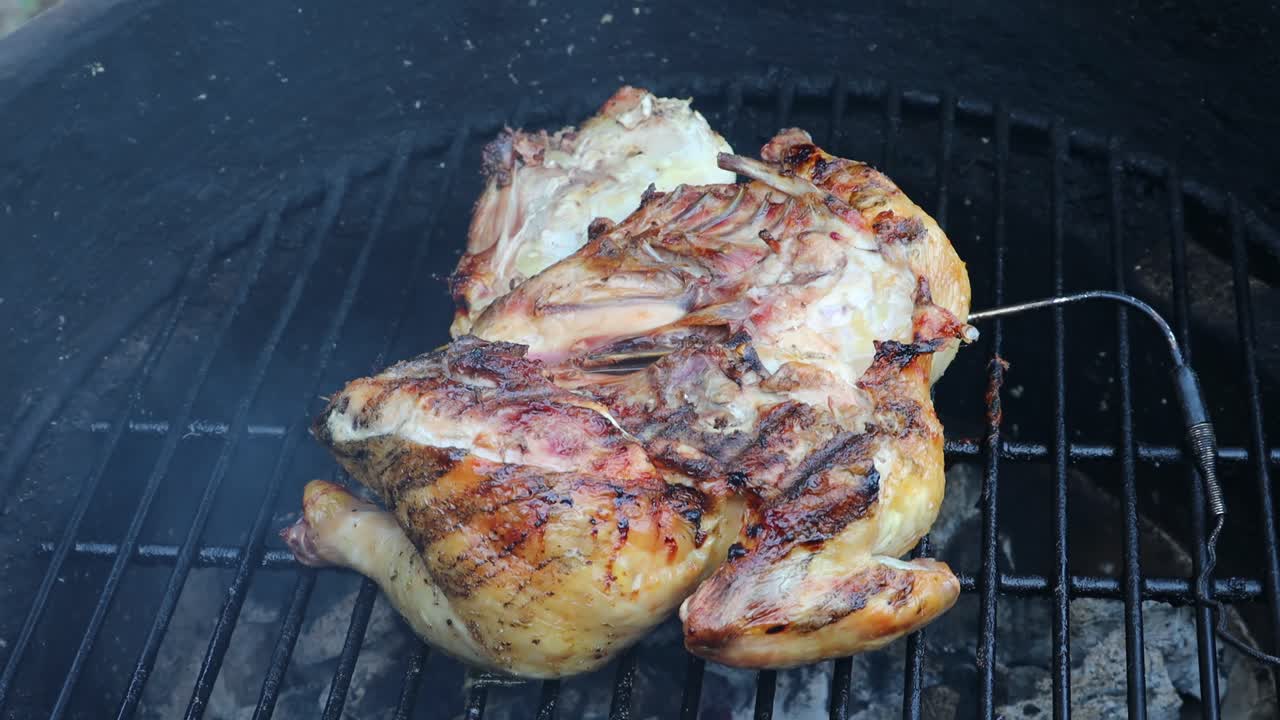 디지털 온도 프로브가 있는 카마도 스타일의 세라믹 그릴에서 구운 버터플라이 치킨 요리