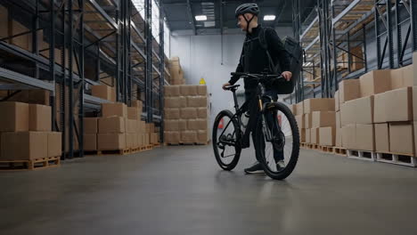 delivery person with bicycle in a warehouse