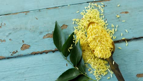 Raw-organic-yellow-rice-and-curry-leaves-on-wooden-table-4k