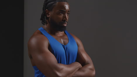 Studio-Portrait-Of-Male-Athlete-Wearing-Vest-Sweating-After-Sport-Training-Or-Exercising-In-Gym-Folding-Arms