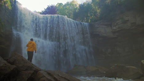 male hiker viewing a large waterfall