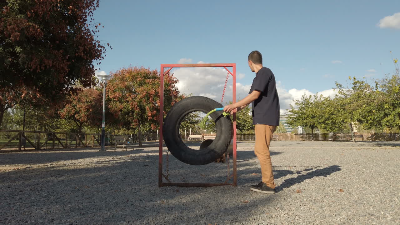 Young man playing and training with a dog. Brown boxer dog
