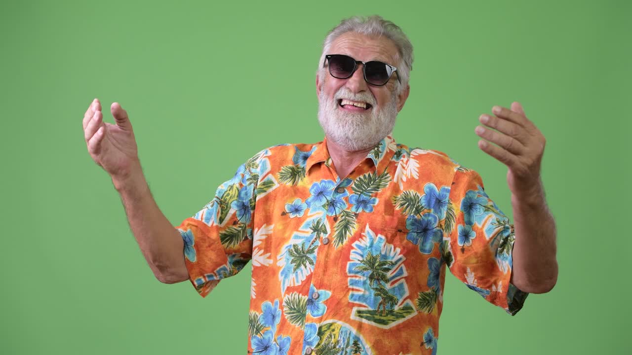 Bell'uomo anziano barbuto, turista, pronto per le vacanze su sfondo verde.