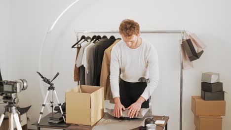 stylish young man packs shoes in a box