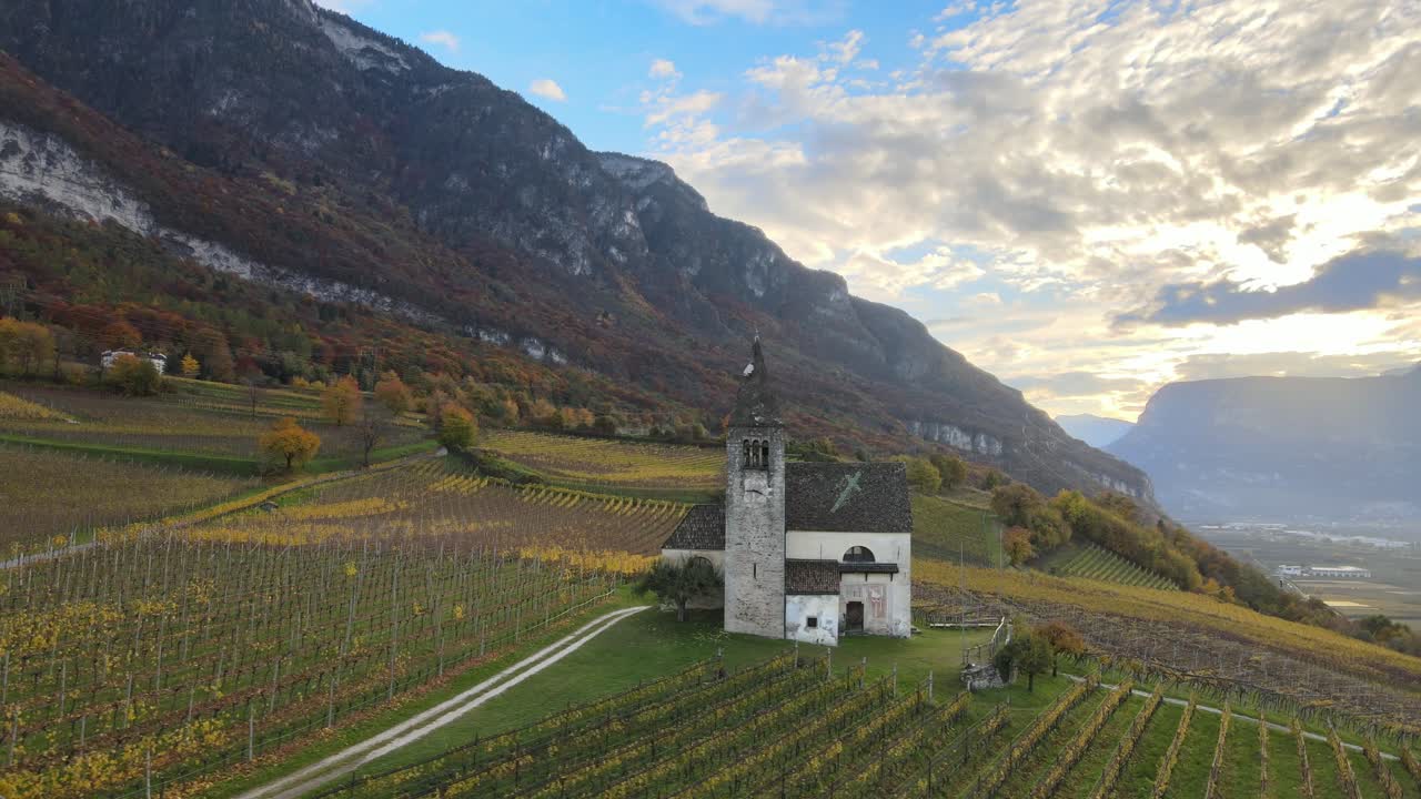 drone aéreo sobre una iglesia medieval en medio de los viñedos en otoño en tirol del sur