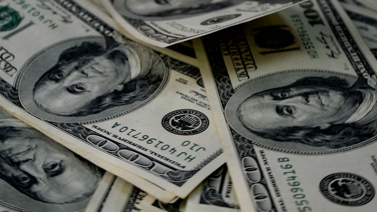 Banconote da cento dollari americani, con il lato dritto rivolto verso l'alto, in rotazione circolare