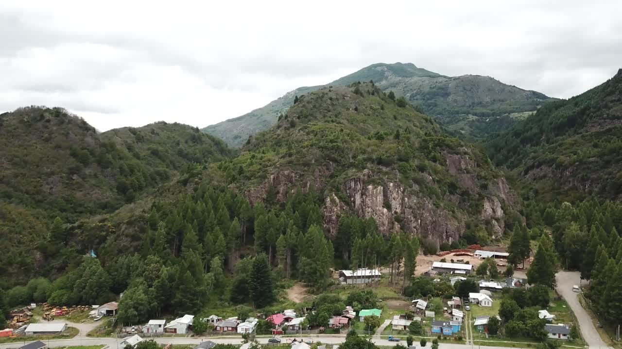 Drone Aerial View of Patagonian Landscape and Small City Under Hills, Villa Maniguales, Chile