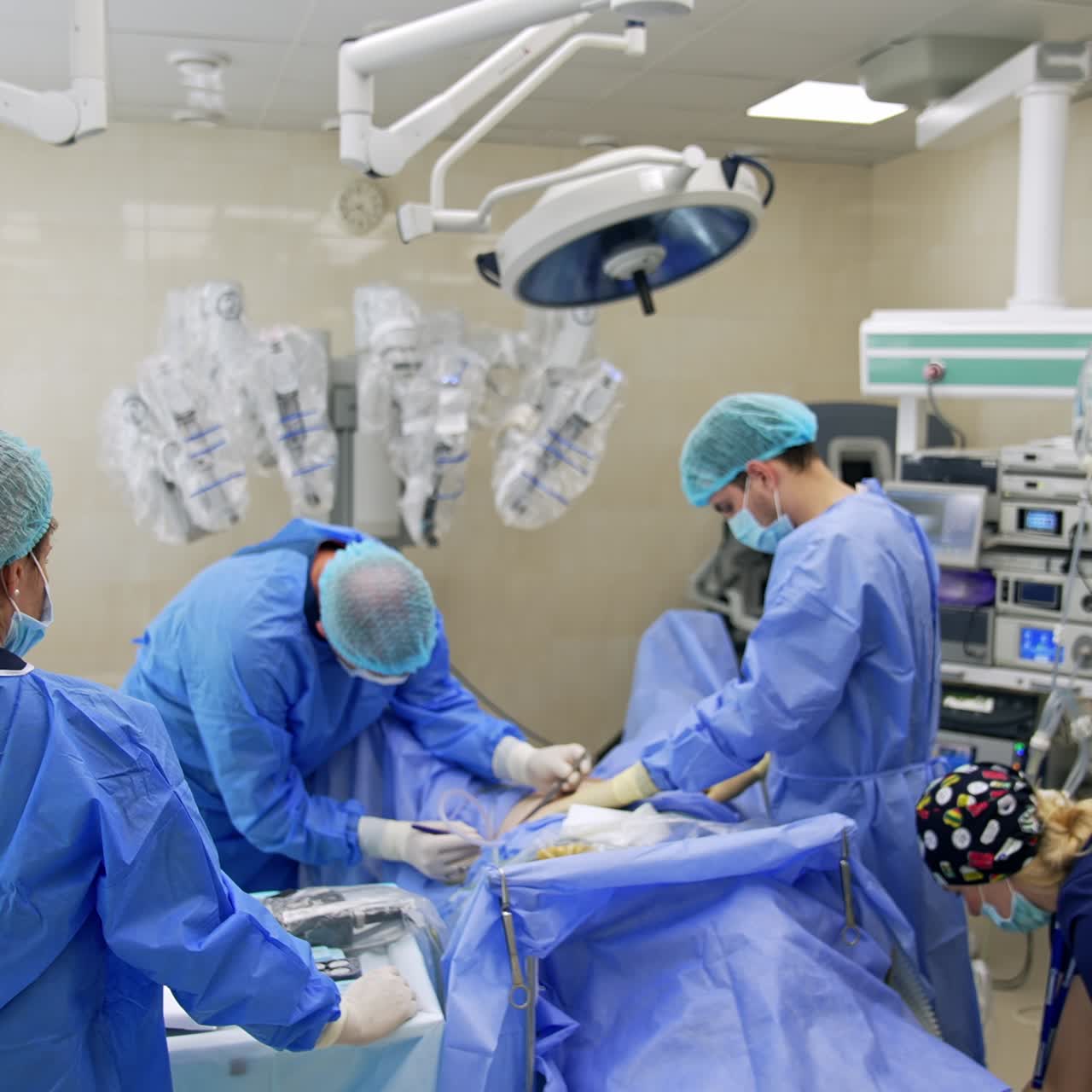 Technically equipped modern surgery room with robotic machine. Big team of professionals are involved in surgical operation