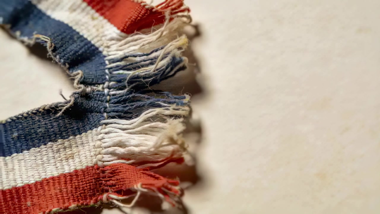 Showing frayed ribbon moving with focus shifts on pale paper, showing tricolor stripes, copy space