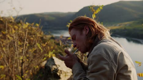 hiker resting while lighting up his cigarette with lighter , vogelberg