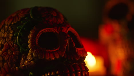 close up on still life of decorated skull lit by candles celebrating mexican holiday of dia de muertos or day of the dead