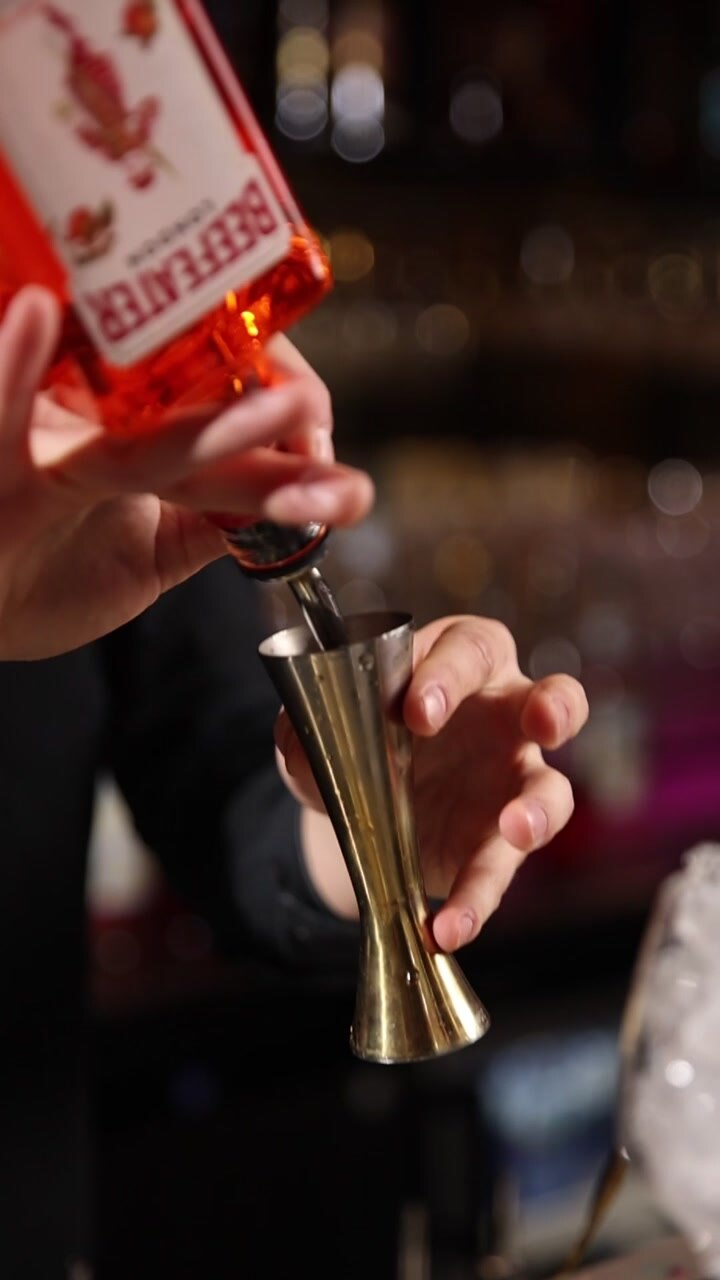 Barman che dosa l'alcol in un misurino in un bar