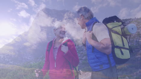 Mature couple hiking mountain trail, tracking fitness data through animated heart rate chart
