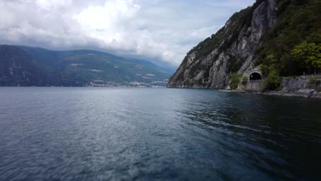 FPV-drone-flying-low-and-fast-over-Lake-Como-water-in-Alps-of-Italy