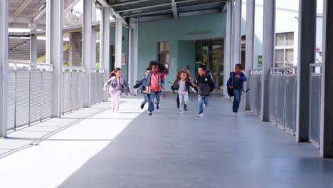 elementary school kids run to camera in school corridor