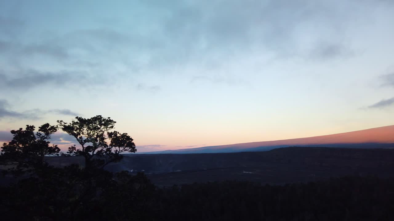 Gimbal wide panning shot of Mauna Loa to Kilauea while looking out from Volcano House at sunrise in Hawai'i Volcanoes National Park