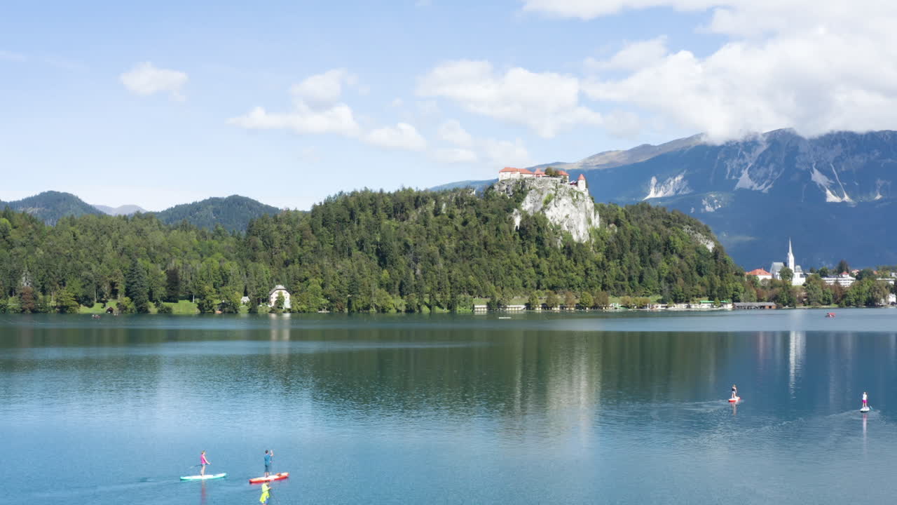 antena - gente en paddleboards, lago bled, alpes julianos, eslovenia, pan ascendente a la izquierda