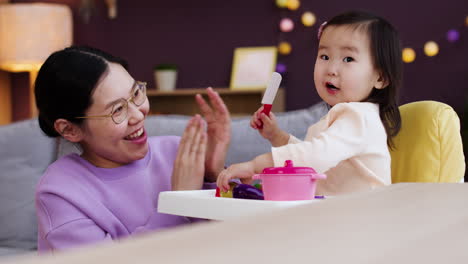 아시안 어머니 가 아기 와 함께 놀고 있다